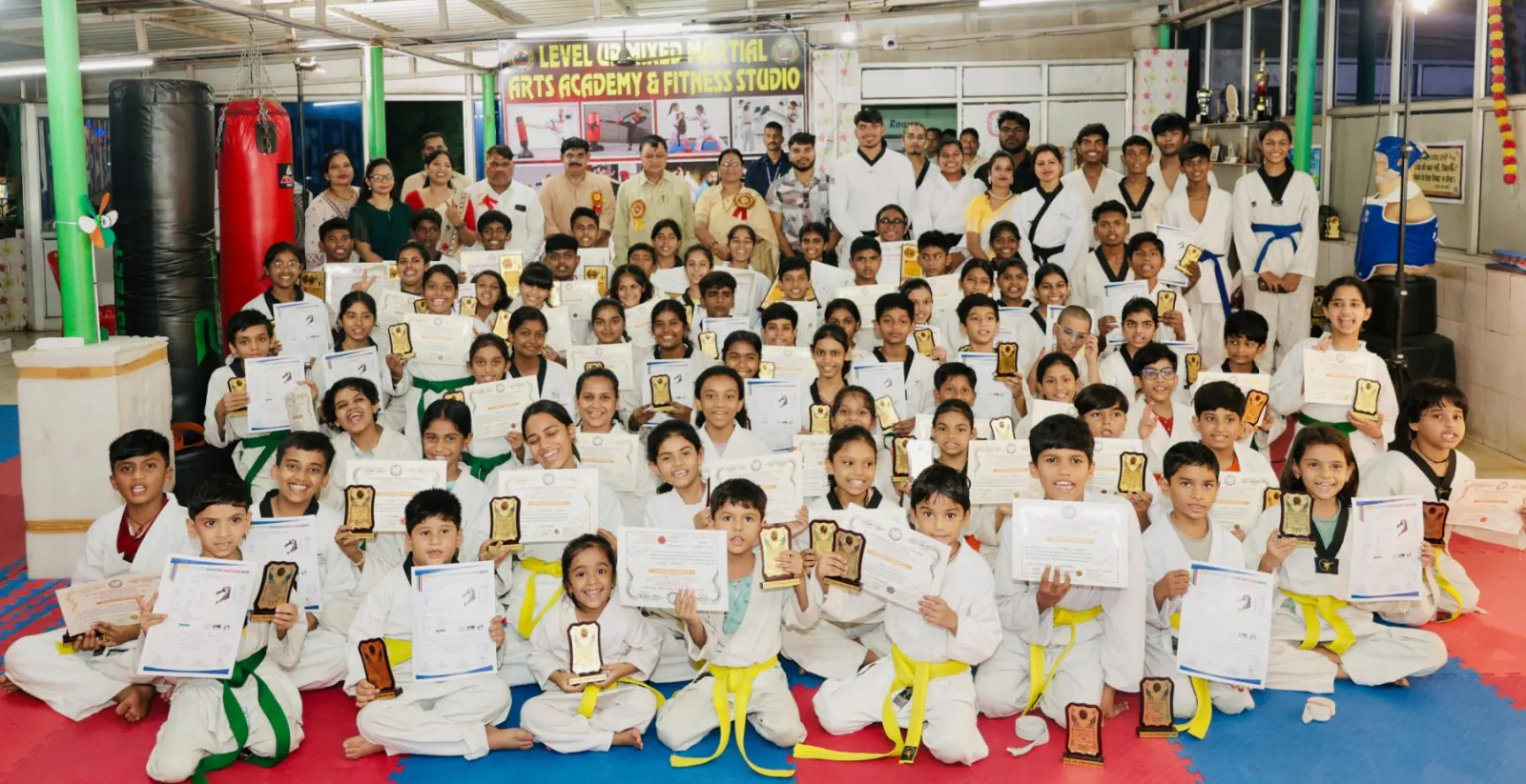 Academy students holding certificates and medals after a grading
